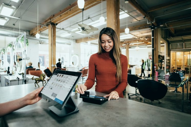 Cashier serving a customer at a counter terminal